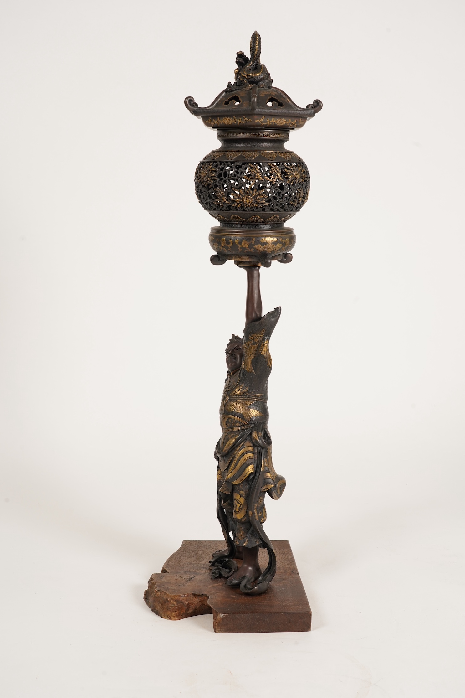 A large Japanese Miyao style parcel gilt bronze figure holding a koro aloft, 20th century